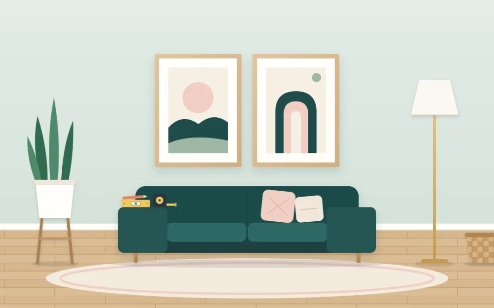 Two framed abstract prints side by side above a small sofa, with a pencil, a tape measure and a small level resting on the sofa arm